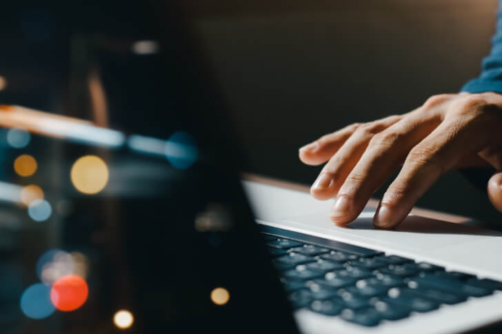 Fingers using a mouse pad on a laptop