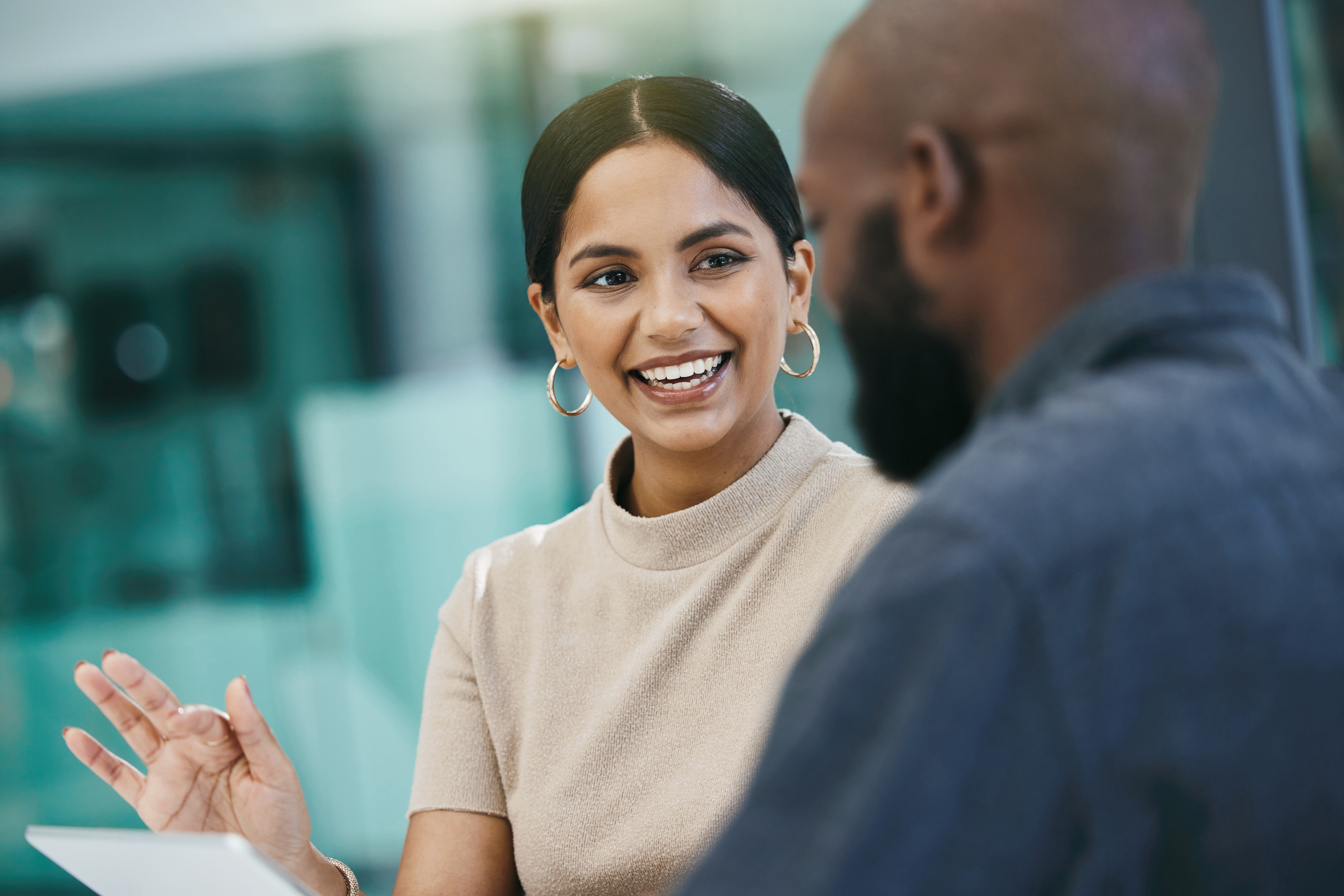 Lady Smiling Using An Ipad While Talking To A Man