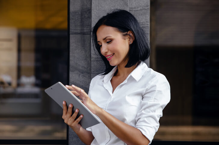 Lady Smiling With An Ipad