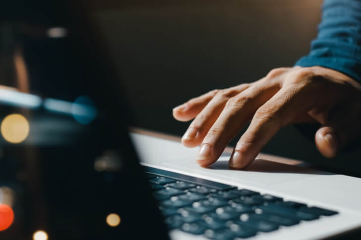Male Hand Navigating A Mouse Pad On A Laptop