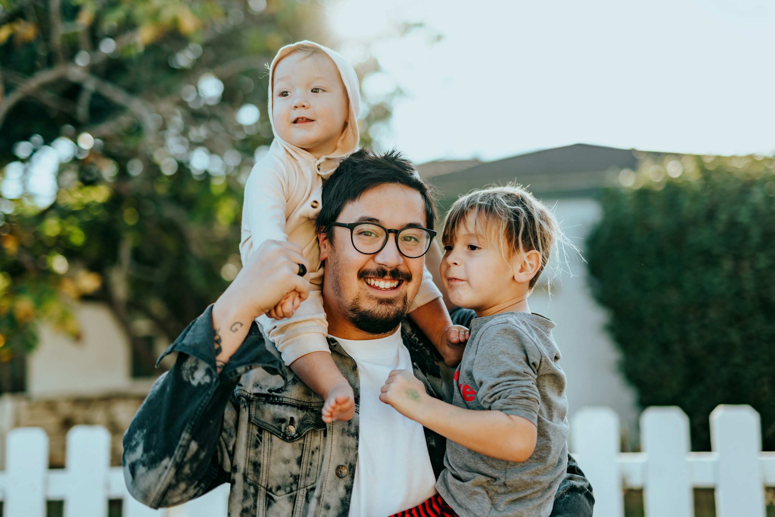 Man Holding One Child With Another Child On Hs Shoulders